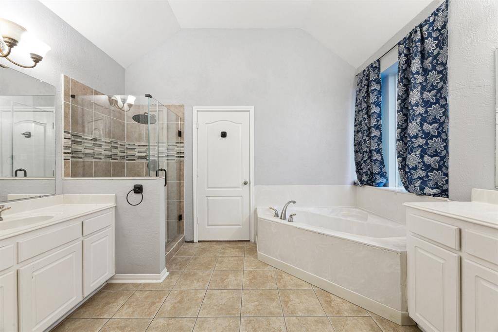 Primary bathroom with separate sinks and a jetted tub