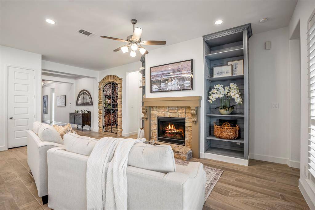 A stone fireplace with a rustic yet elegant mantle serves as the focal point of the room.The fireplace is gas-powered, adding both warmth and ambiance to the space.Above the mantle, a mounted TV or art piece provides additional visual interest. This living room is both functional and stylish, ideal for family gatherings or quiet evenings by the fire.