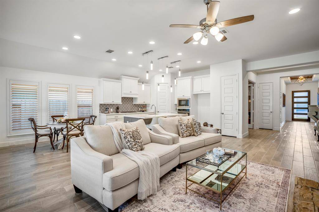 A stone fireplace with a rustic yet elegant mantle serves as the focal point of the room.The fireplace is gas-powered, adding both warmth and ambiance to the space.Above the mantle, a mounted TV or art piece provides additional visual interest. This living room is both functional and stylish, ideal for family gatherings or quiet evenings by the fire.