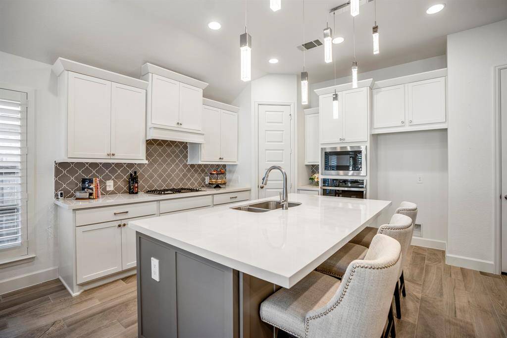 The large island with additional counter space, a sink, and a dishwasher beneath, perfect for food prep and entertaining.