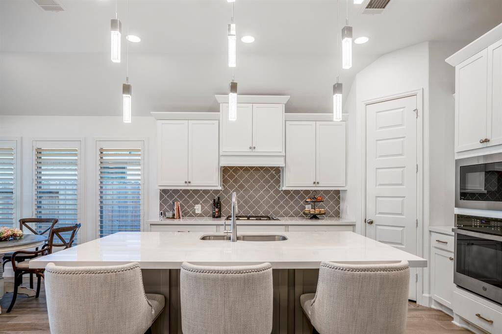 Pendant lights hanging above the island add a soft, sophisticated ambiance.