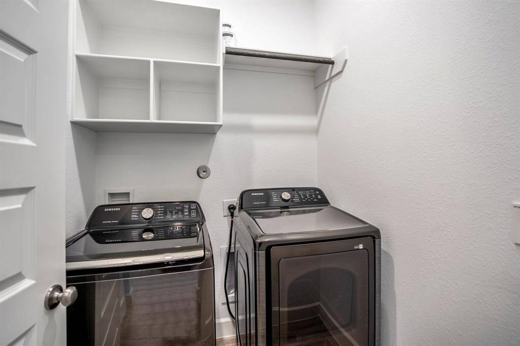 The laundry room, washer and dryer included, also offers extra storage with plenty of shelving and a hanging rack.