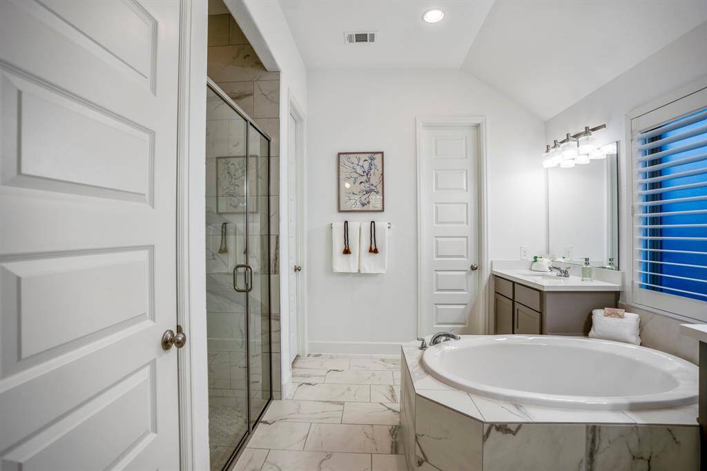 A harmonious combination of whites, grays, and natural tones creates a timeless and relaxing atmosphere.This primary bathroom combines style and practicality, offering a private retreat for unwinding at the end of the day.