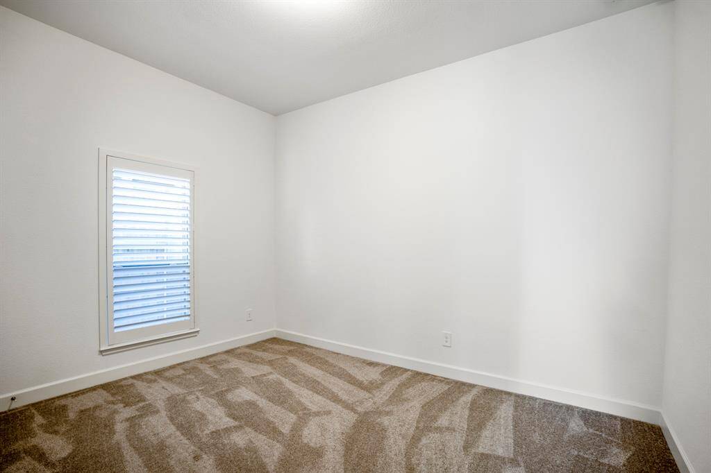 This is the second secondary bedroom, designed to be a versatile and comfortable space.  The open floor plan offers flexibility for different configurations, accommodating a bed, desk, or other furniture pieces.