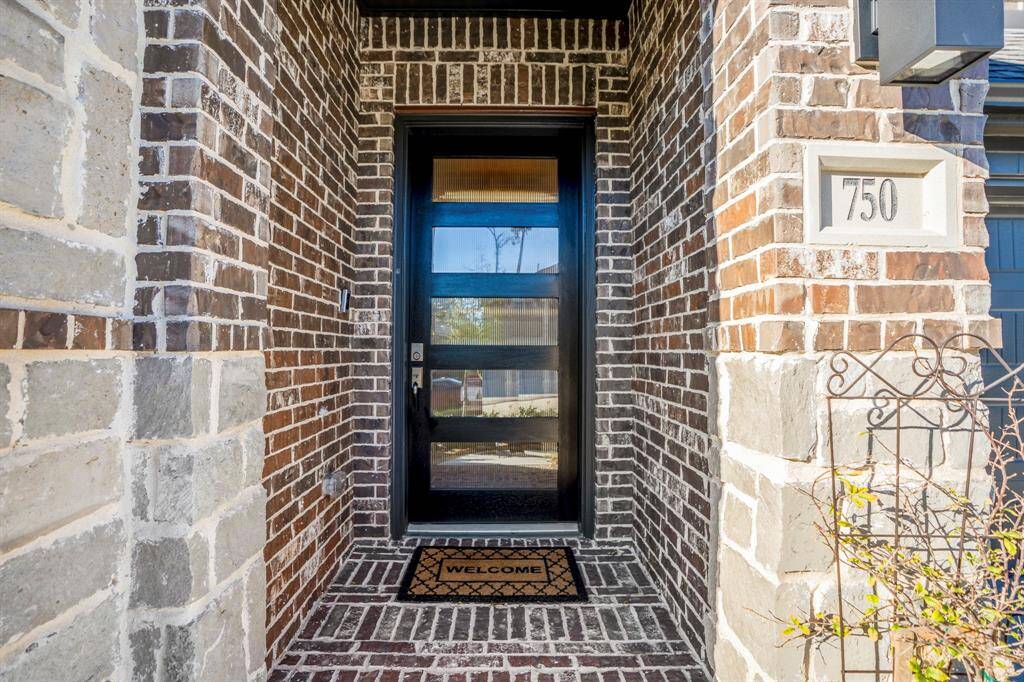 The entryway is sheltered, providing protection from the elements and adding depth to the facade. The covered area creates a cozy space for decor, such as planters or seasonal decorations. The blend of materials enhances the home’s curb appeal with a sophisticated look.