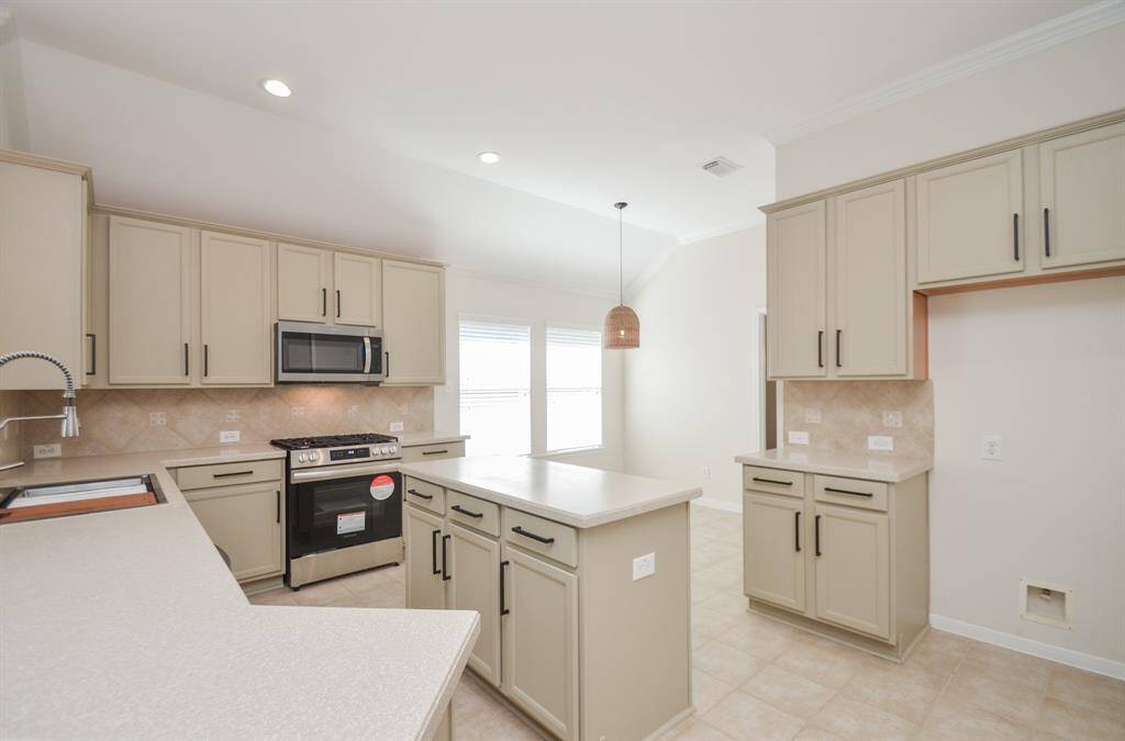 Warm earth tones bathe abundant cabinetry, floors, counter tops and backsplash in a cooks' dream kitchen.