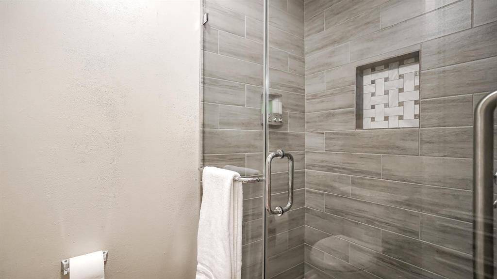 There is an updated shower with tile surround and a seamless glass door.