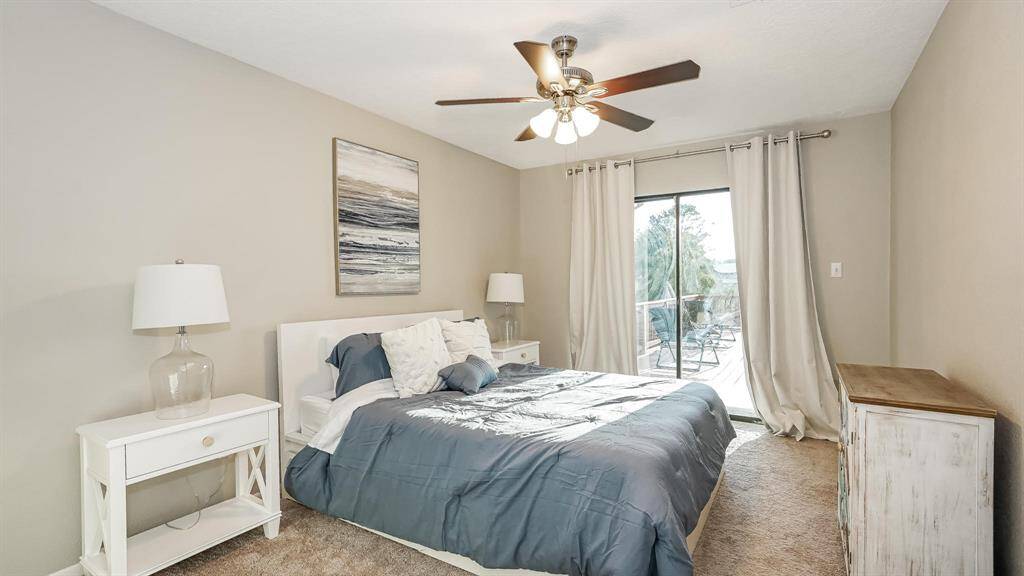 The second bedroom has carpet floors, a ceiling fan and sliding glass doors to access the patio area.