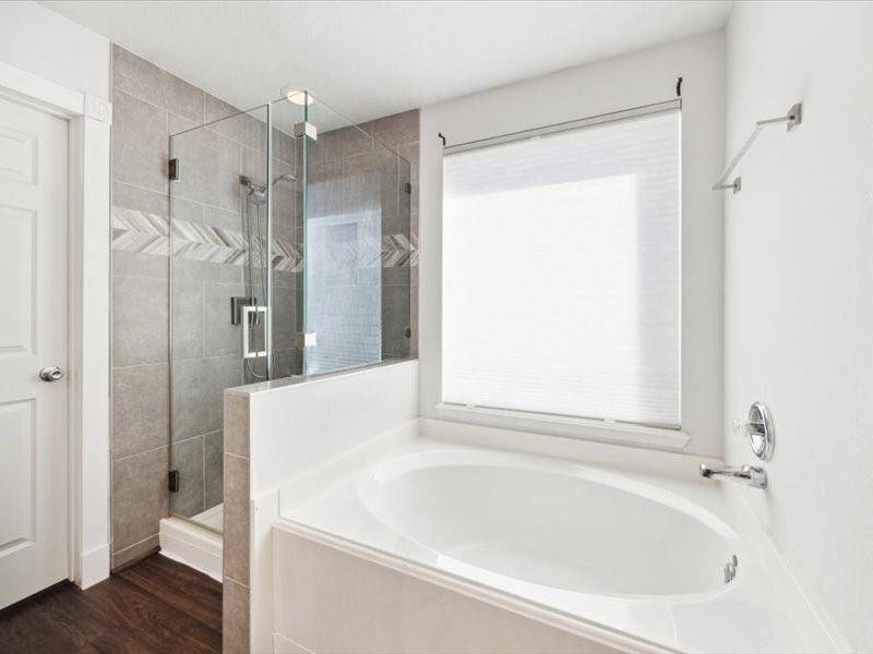 Frameless shower with recently remodeled tile wall. Large soaking tub, perfect for relaxing.