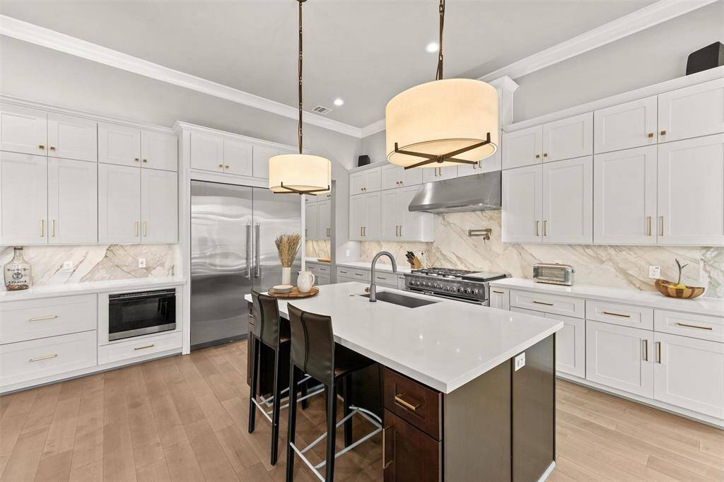 Restoration Hardware® pendants over the island, and under/over cabinet lighting illuminate this area.