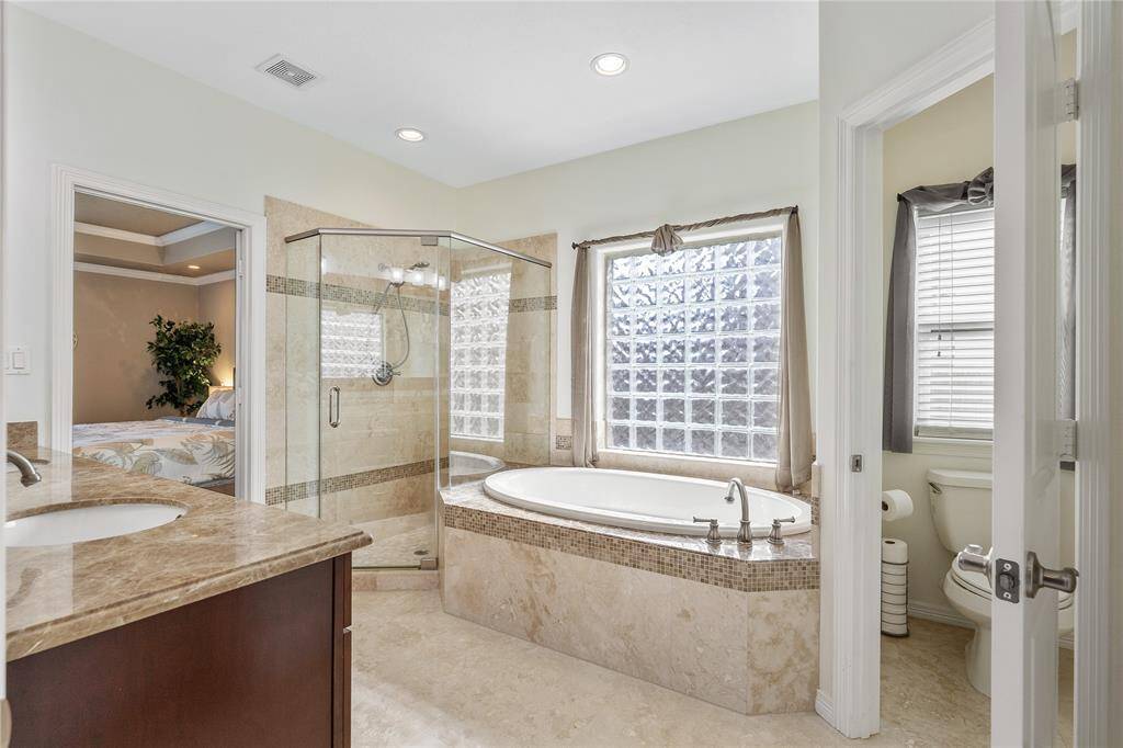 This luxury bathroom is in pristine condition with a seamless design that matches the rest of the home.
