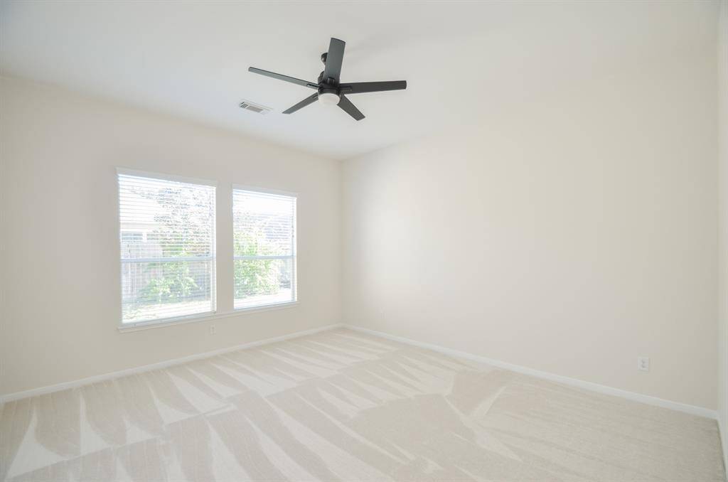 A carpeted secondary bedroom welcomes pure natural light; and offers great wall/floor space.