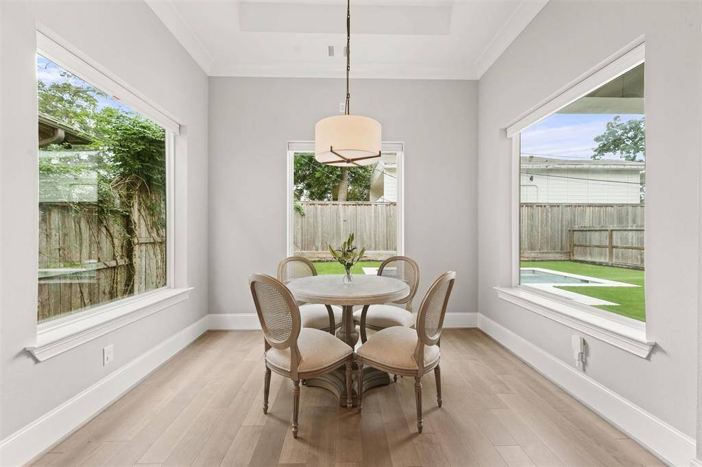 A lovely Restoration Hardware® pendant floats above the breakfast table in this generously sized room. Windows on three sides provide views for days, and motorized