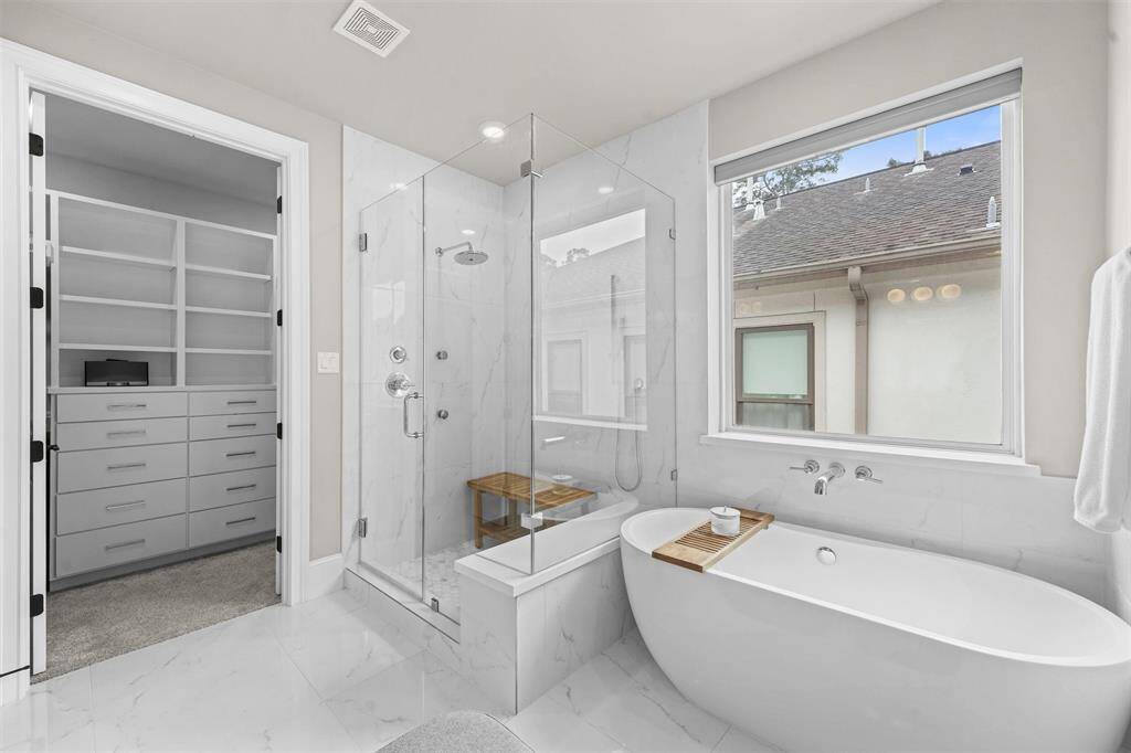 Take your pick: soaking tub, or frameless shower with rainhead and two body sprayers? Note the owner's closet is through the door on the left!
