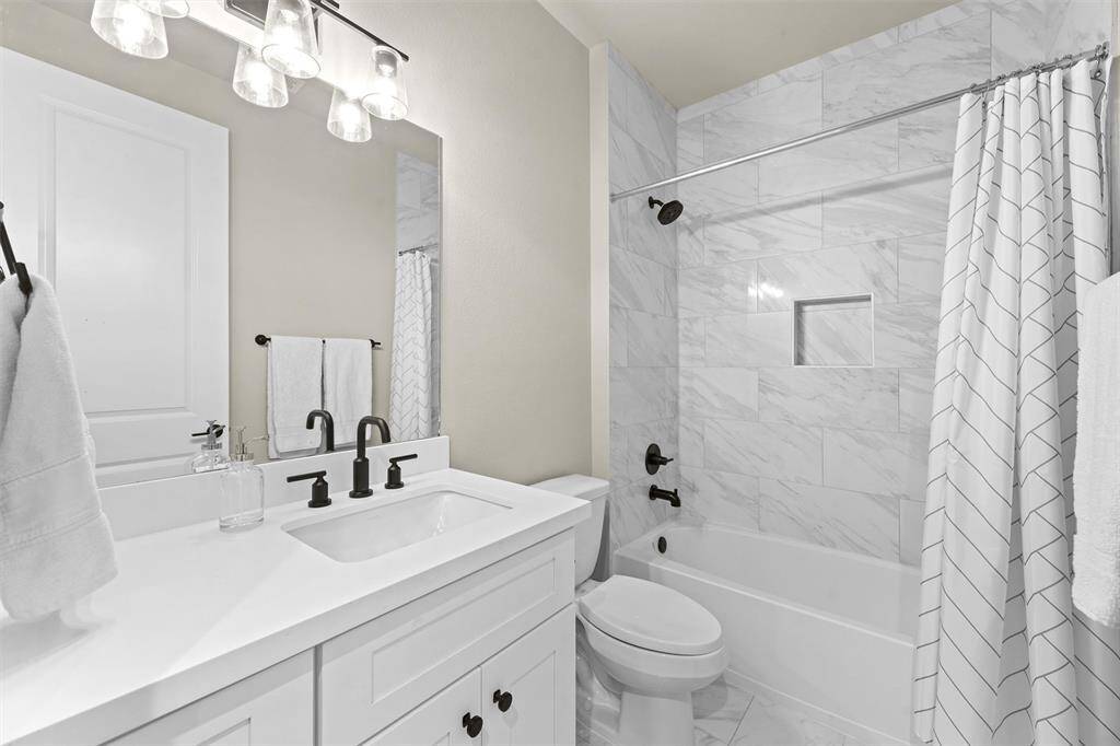 Secondary Bathroom #1, which services Secondary Bedroom #1 and also the gameroom. A single sink, plenty of counterspace, and a shower/tub combo.