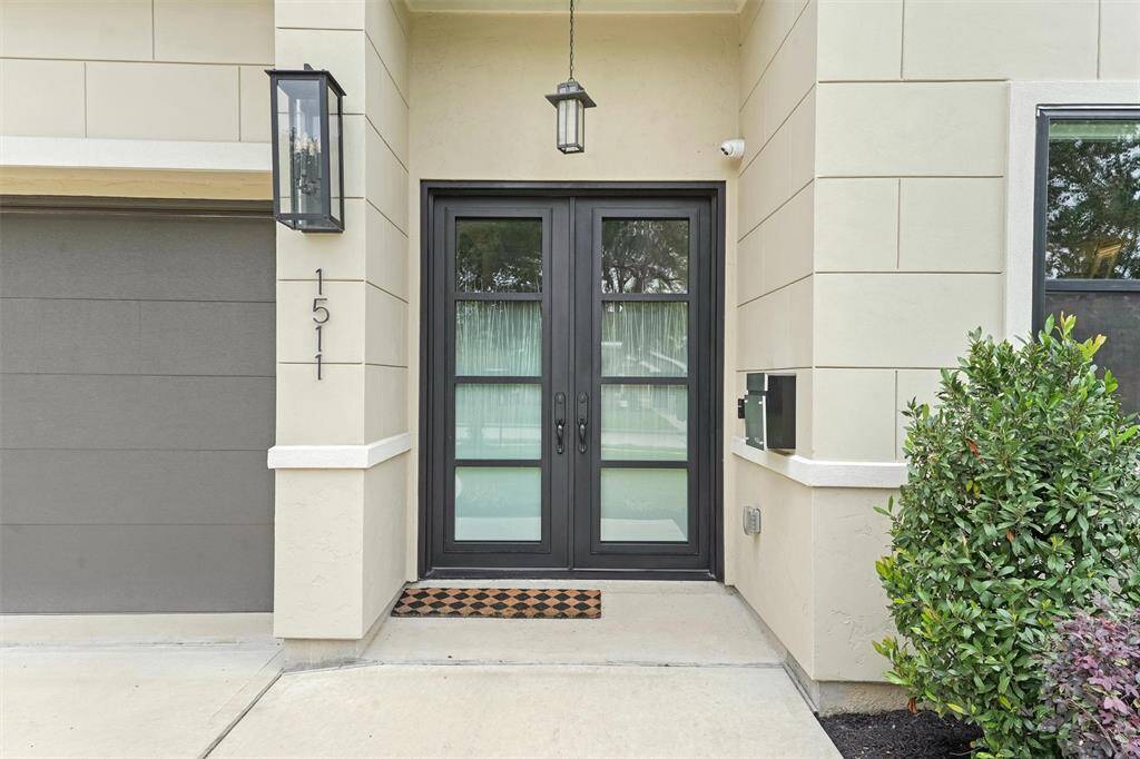 Double iron doors set the tone for the elegant aesthetic of this home. The custom glass etching is beautiful and provides privacy.