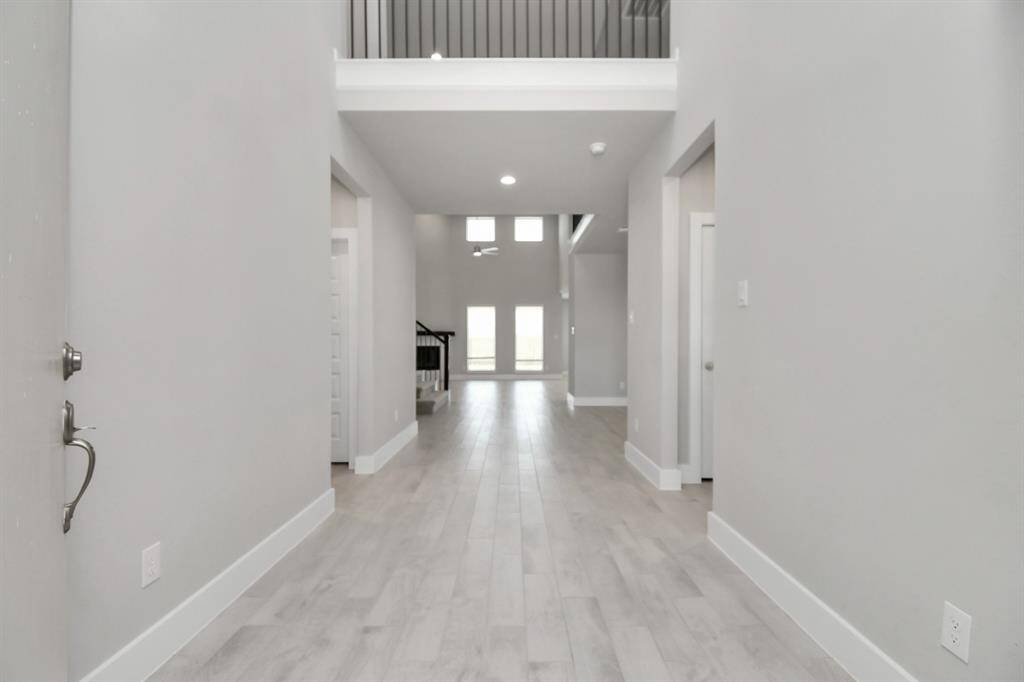 Indulge in luxury as you step into the threshold of this breathtaking home. The grandentrance beckons with its soaring ceilings, adorned with elegant wood-look tile flooringfeaturing sleek oversized baseboards. Sample photo of completed home with similar floor plan. Actual colors and selections may vary.
