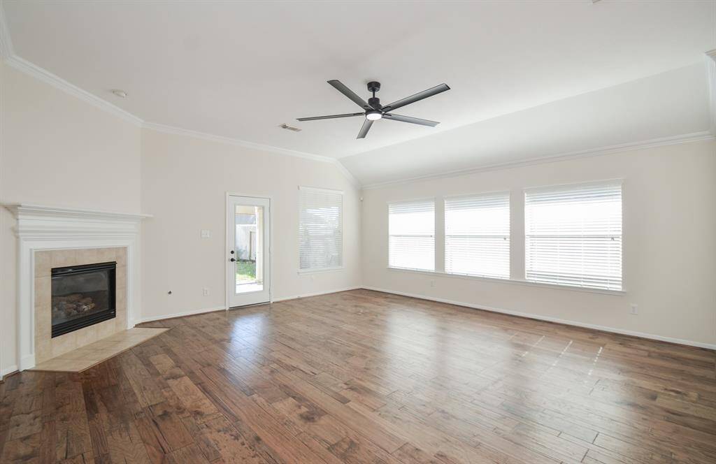 Wow! The main hallway takes us to this incredibly spacious and naturally bright living/family area; with walls of windows and the star-of-the show, a gorgeous built-in gas log fireplace!