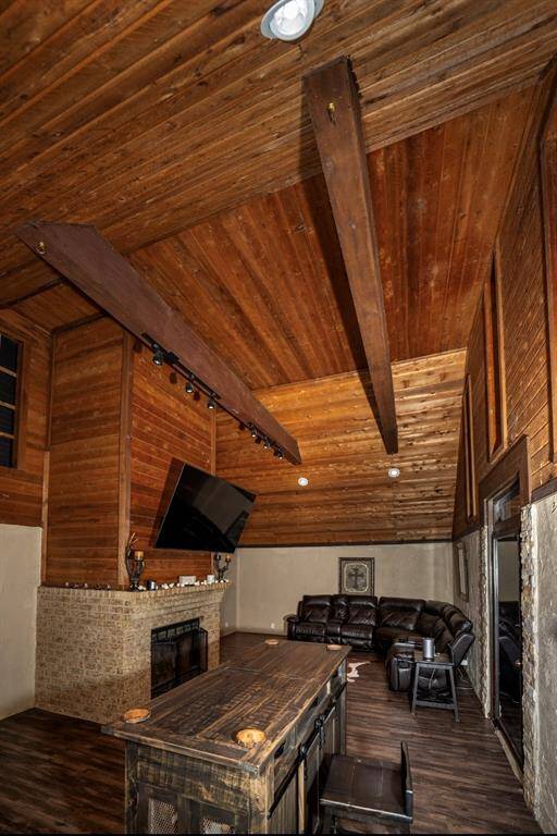 This cozy living space features a vaulted wooden ceiling with exposed beams, a brick fireplace, and perfect for your mounted TV. It includes a comfortable seating area. The rustic charm is enhanced by warm wood accents.
