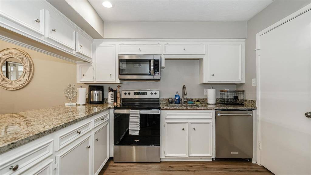 The kitchen has granite counters, SS dishwasher, SS refrigerator, SS microwave, SS electric range with electric oven and LED recessed lighting.