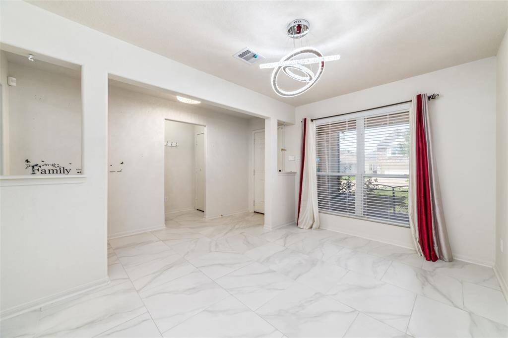 This is a bright, modern room featuring sleek white porcelain flooring, a unique circular light fixture, and large windows includes a built-in shelf space and a clean, neutral color palette.