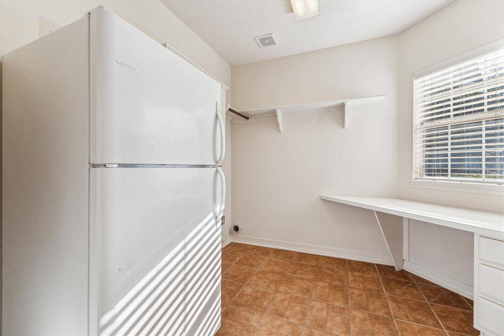 Spacious tiled utility area with 2nd ref area and a cloth folding area. Large window bring plenty of light into this large utility room. Refrigerator in utility room will stay.