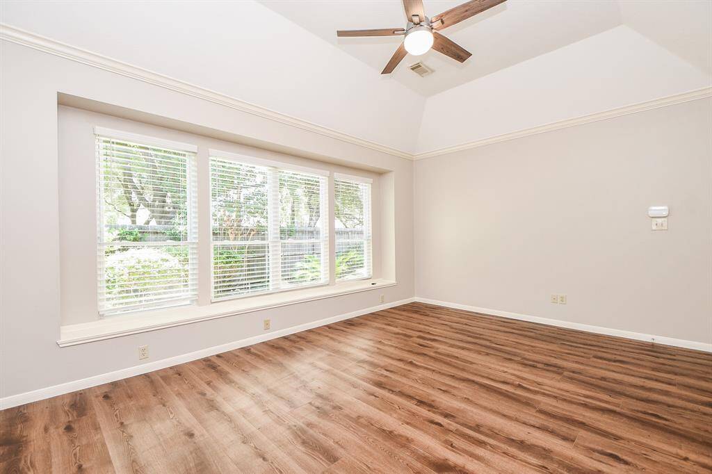Primary Bedroom features large picture window and raised ceiling.