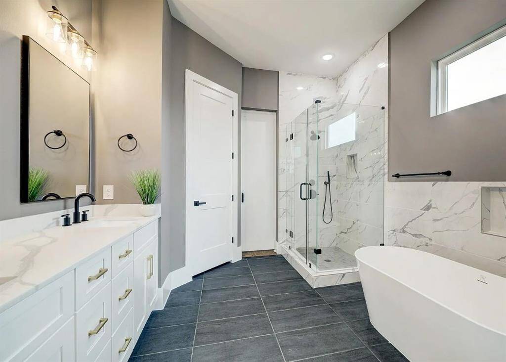 Primary bathroom with a relaxing soaking tub, double sinks, spacious shower, and a walk-in closet for plenty of storage.