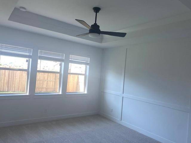 Spacious primary suite with feature wall and ceiling treatment