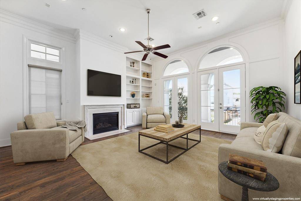 Virtually staged family room with gas log fireplace, hardwoods, custom window shades and double door access to north facing patio.