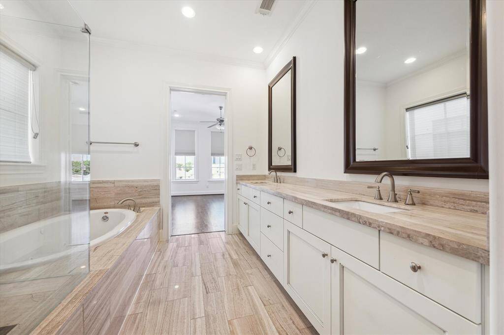Beautifully appointed primary bath features soaking tub, double sink vanity and seamless shower stall.