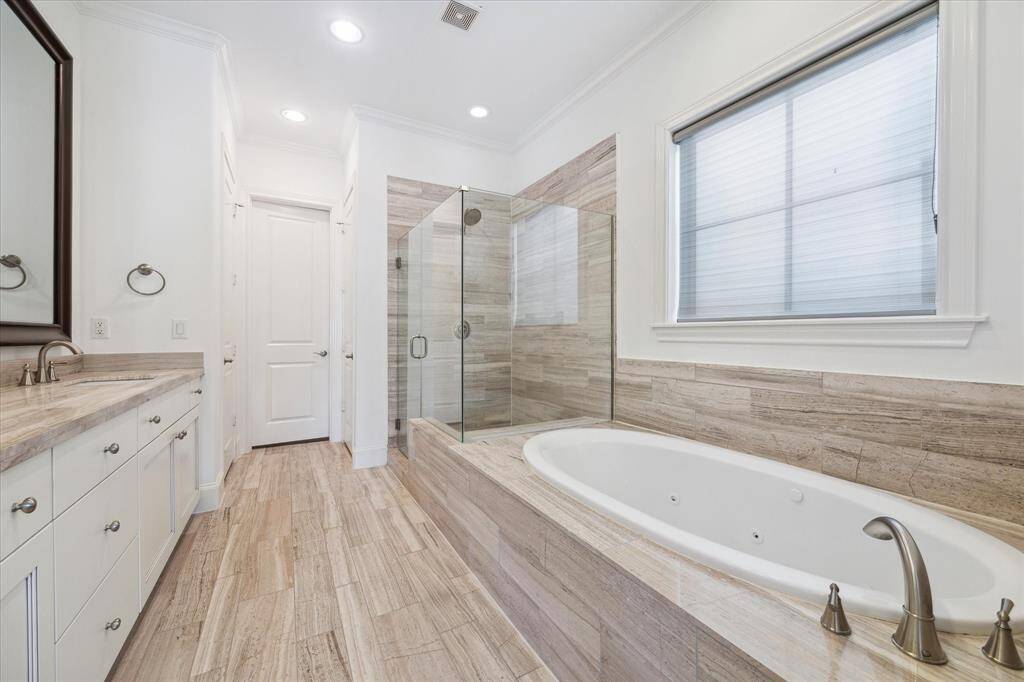 Primary bath with spa tub, seamless shower stall and window with custom roll-down shade.