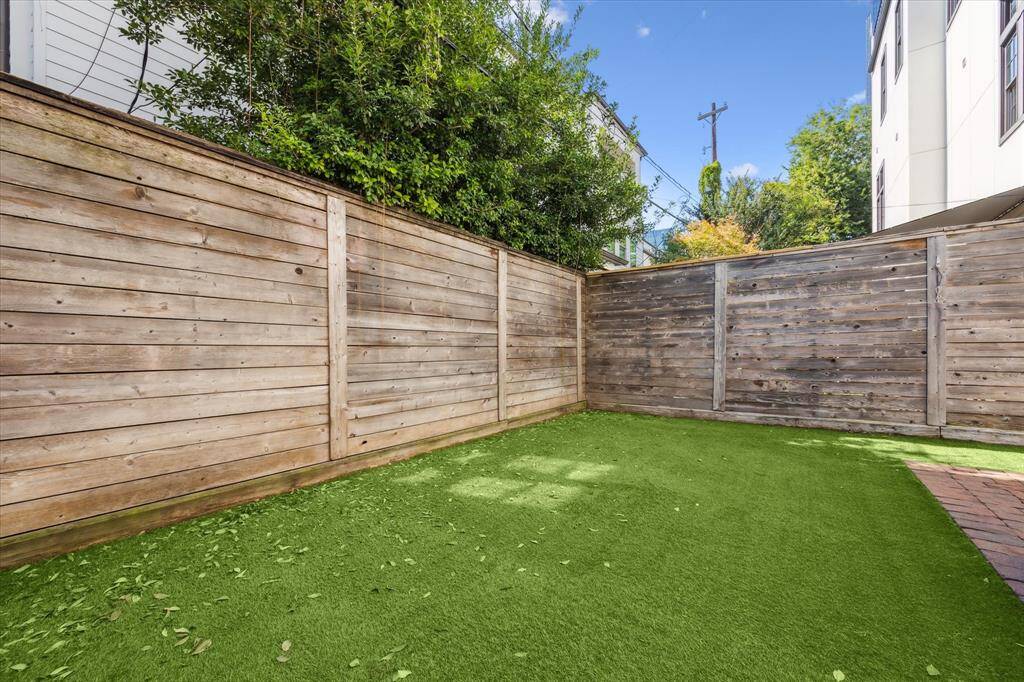 Backyard with privacy-enhancing screen of mature hollies.