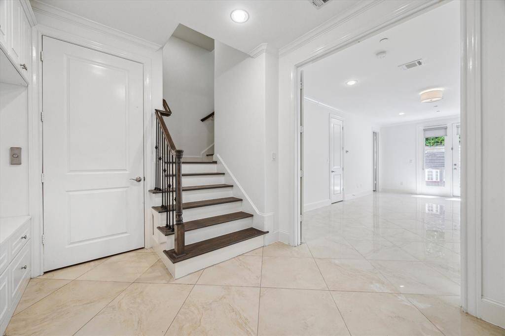 Same as previous view but no virtual staging. First floor elevator door is just to the left of stairs offering easy access from main entry and/or garage. Convenient for conveying groceries, luggage or other items to bedrooms, living rooms or kitchen on floors above.