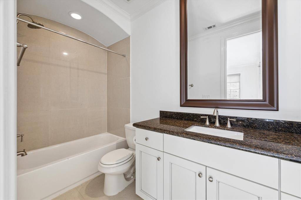 First floor en suite bathroom with marble tiled floor, granite vanity and tub / shower.