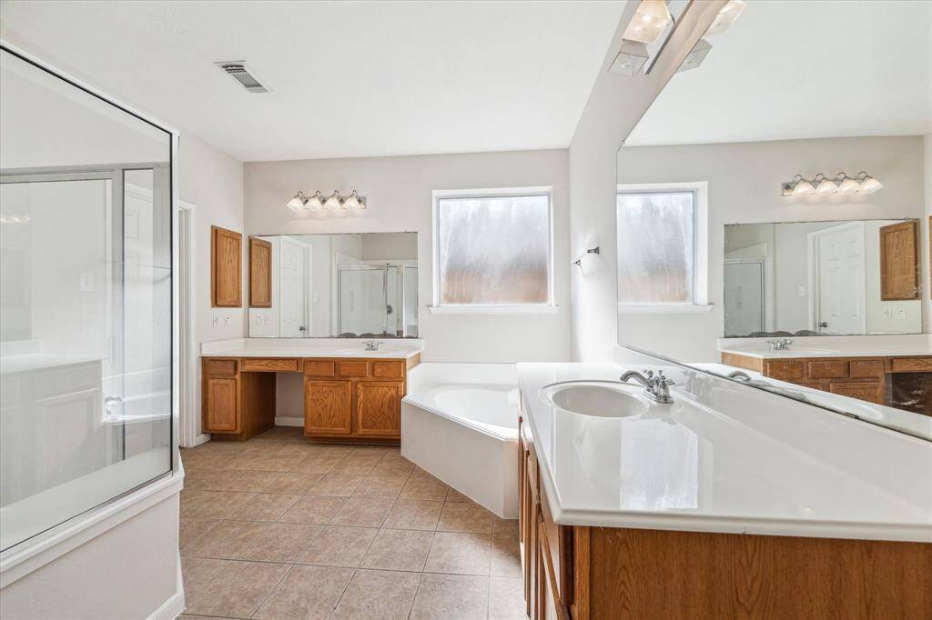 His and her sinks with a large soaking tub and a walk-in shower.