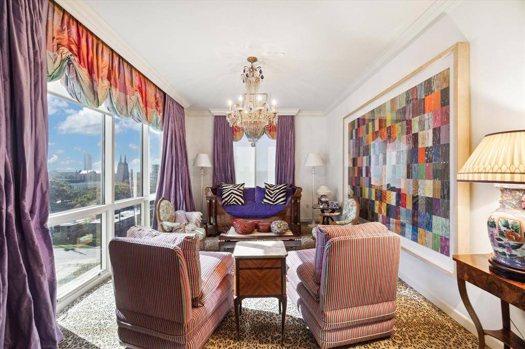 A large sitting room in the primary bedroom with floor to ceiling windows. The perfect area to relax at the end of the day or have a coffee in the morning.