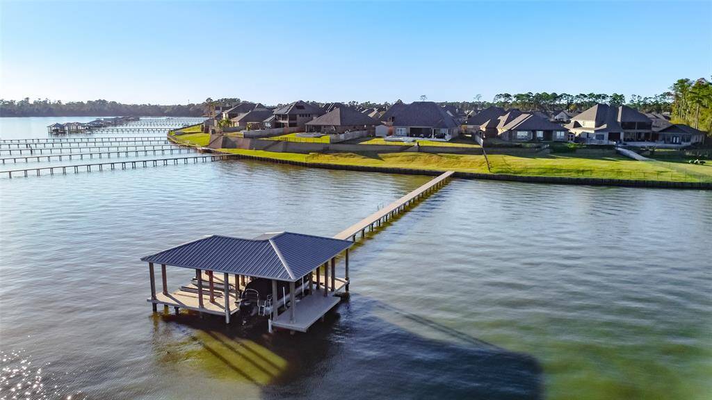 Experience stunning sunsets from the custom boathouse, complete with a private dock jet ski lifts, perfect for enjoying Lake Houston's beauty.
