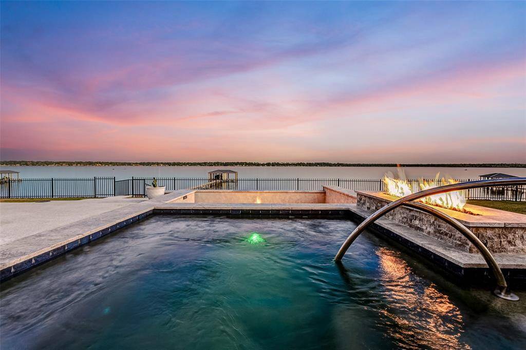 A stunning first impression, showcasing the elegant facade of this 2020-built Emerald Homes design full of curb appeal. It sits on a 36,000+ waterfront lot and features a three car garage