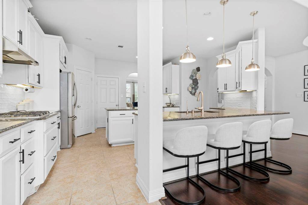 The expansive gourmet kitchen surrounds you with custom cabinetry and a breathtaking backsplash, creating a truly stunning culinary space!