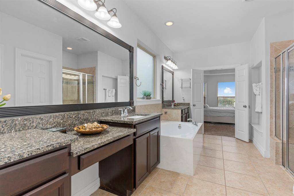 Her vanity area is designed with a cozy sitting nook for those beauty routines! Lush granite countertops with deep undermount sinks and many more luxurious details make this space truly special.