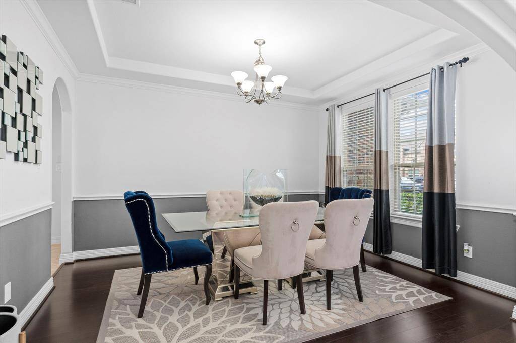 The elegant formal dining area features high coffered ceilings and crown molding, with direct access to the gourmet kitchen, making serving a breeze!