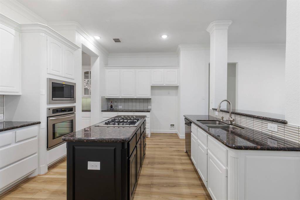 Updated kitchen with sleek granite countertops, ample cabinetry, new backsplash and freshly painted cabinets perfect for culinary adventures.