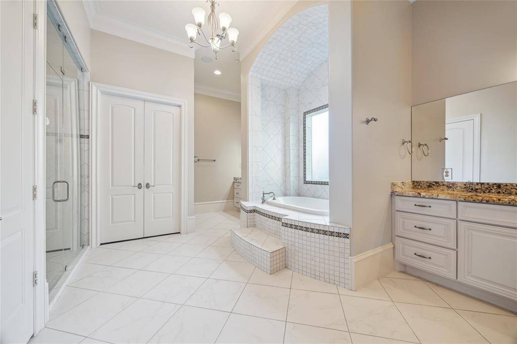 Enjoy ample storage with classic cabinetry, all under a stylish chandelier.
