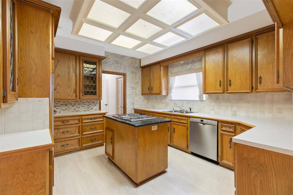 Large Kitchen features Custom Cabinets and Drawers plus Island with Cooktop & Granite Countertop