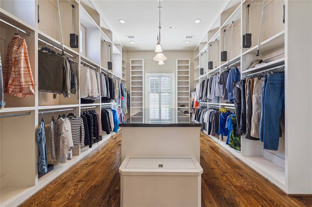 Spacious, elegantly designed walk-in closet. Featuring ample shelving, hanging space, and a center island, it's the perfect blend of functionality and sophistication for your wardrobe needs.