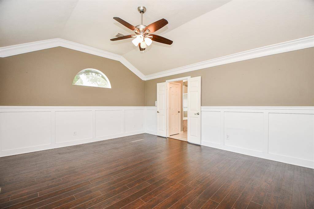 Large master bedroom with wood floors.