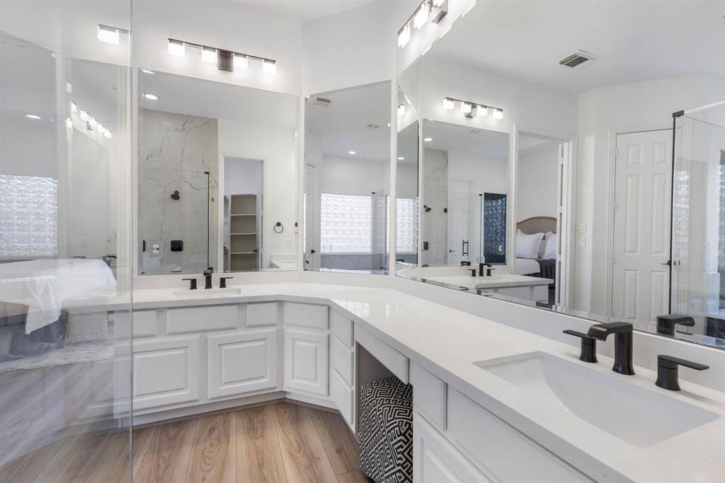 Elegant primary bathroom with dual sinks in a spacious, bright bathroom, perfect for serene mornings.
