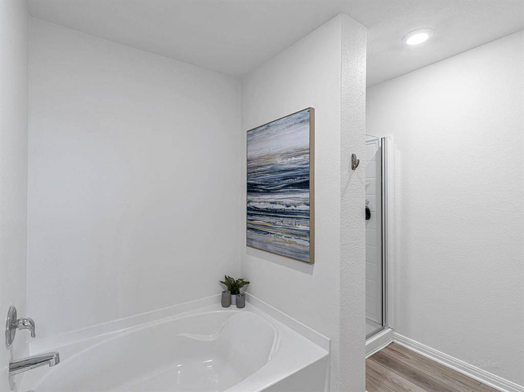 The primary ensuite bathroom features a separate garden tub & shower, allowing for ultimate relaxation. One of the standout features of this ensuite is the massive walk-in closet, which spans the entire length of the bedroom, offering an incredible 90 square feet of storage space.