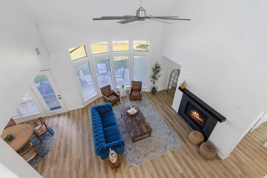 Bask in the warmth of natural light streaming through expansive windows, illuminating this charming living area.
